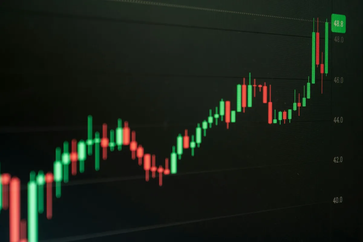 Candlestick stock chart trending upward on a dark screen.